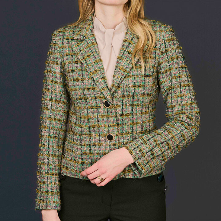 Green and brown woman wool boucle jacket with black Chanel-style buttons.